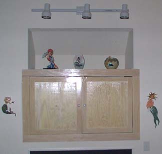 A small entertainment center cabinet<br />that is above a fireplace.